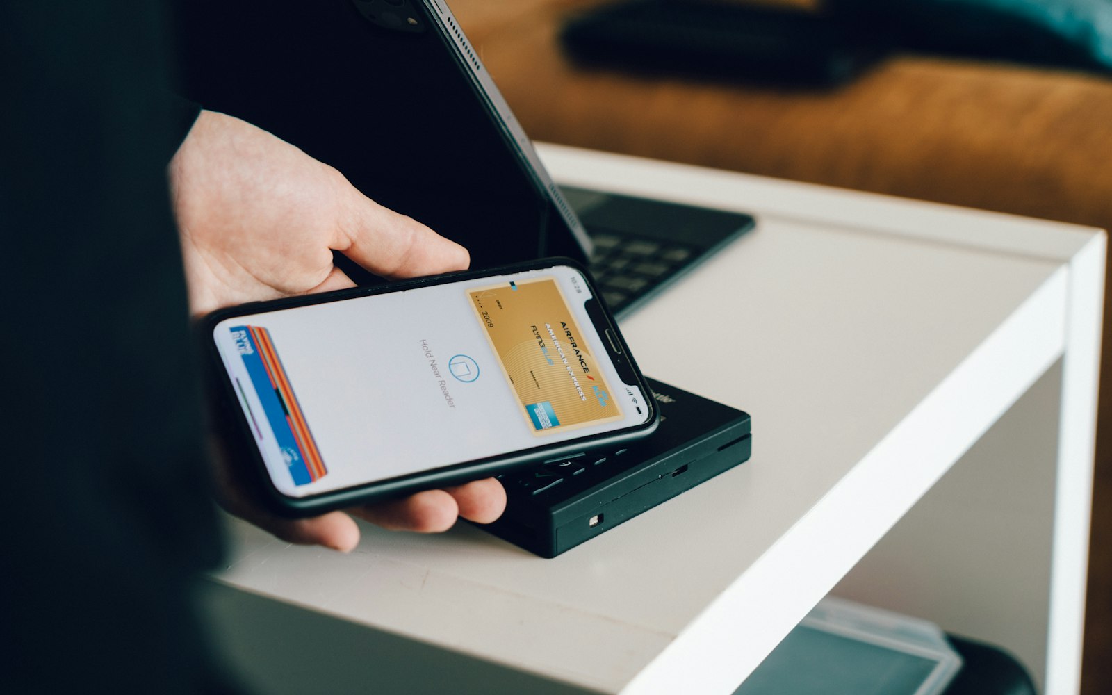 A phone held over a card reader to make a contactless payment