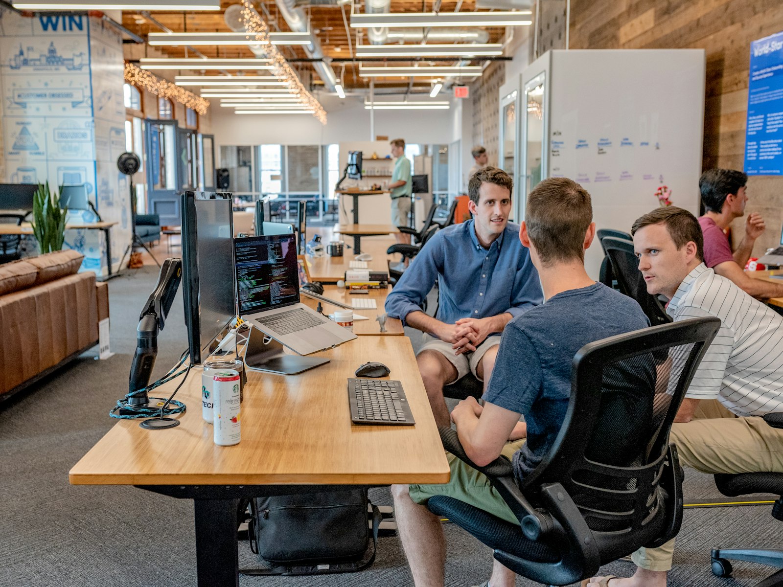 Colleagues talking around desks in a bright open-plan office